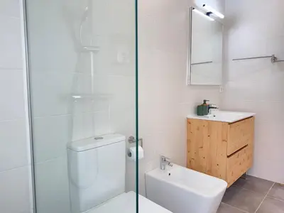 a white bathroom with a toilet and a sink at Villa Leonardo in Castelldefels