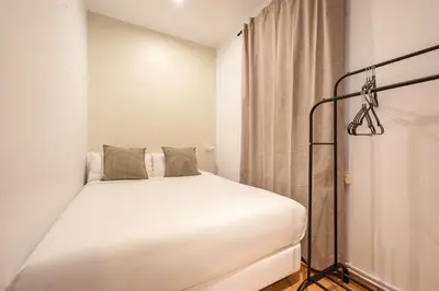a bedroom with a white bed and a curtain at Sweett - Vicky Barcelona in Barcelona