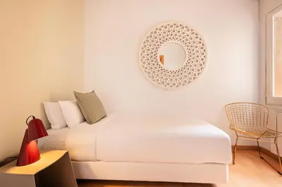a white bedroom with a bed and a mirror at Sweett - Vicky Barcelona in Barcelona
