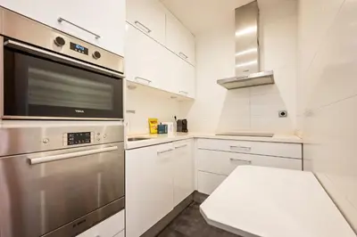 a kitchen with white cabinets and a stainless steel appliance at Sweett - Vicky Barcelona in Barcelona