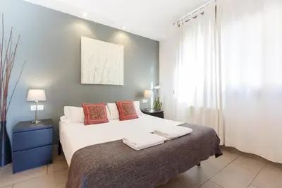 a bedroom with a white bed with towels on it at Playa Beach Barcelonastuff Apartments in Barcelona