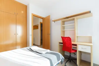 a bedroom with a bed and a desk and a red chair at Playa Beach Barcelonastuff Apartments in Barcelona