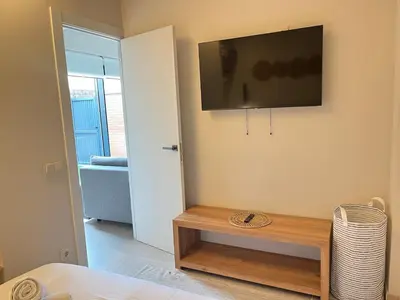 a living room with a television on a wall at Beautiful renovated studio in Castelldefels