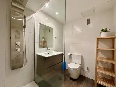 a bathroom with a toilet and a sink and a shower at Spacious home in Bonanova in Barcelona