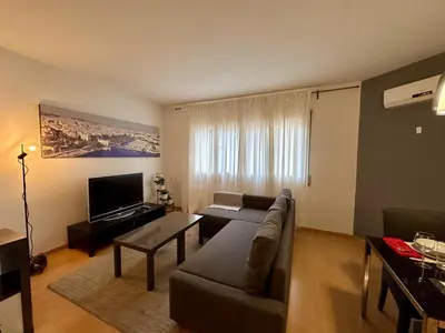 a living room with a couch and a television at Spacious home in Bonanova in Barcelona