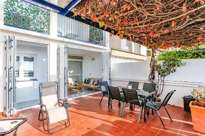an outdoor patio with a table and chairs at AIGUADOLÇ APARTMENT in Sitges