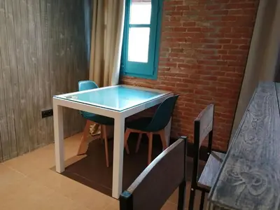 a table in a room with chairs and a brick wall at Beachfront apartment Barceloneta Street in Barcelona