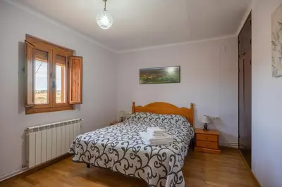 a bedroom with a bed and a window at Mas Prat in Pla del Panadés