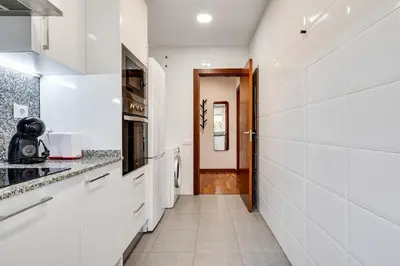 a kitchen with white appliances and a hallway at Acogedor apartamento en el corazón de Sant Antoni in Barcelona