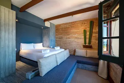 a bedroom with a bed and a couch and a window at Beach apartment with sea views in Barcelona