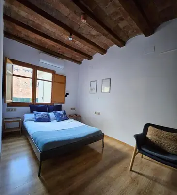 a bedroom with a bed and a chair in it at Flat with 2 rooms and private terrace min 32 days in Barcelona