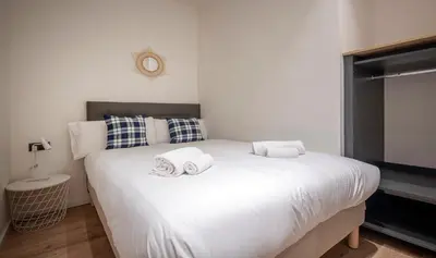 a bedroom with a large white bed with towels on it at Apartamento de cuatro dormitorios en Carrer Diputació in Barcelona