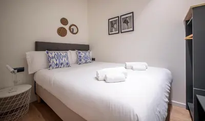 a bedroom with a white bed with towels on it at Apartamento de cuatro dormitorios en Carrer Diputació in Barcelona