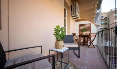 a balcony with a table and chairs and a plant at Apartamento de cuatro dormitorios en Carrer Diputació in Barcelona