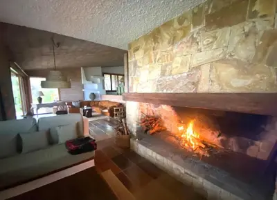 a living room with a large stone fireplace at Villa Juny Best view in North Barcelona Coast in Cabrils