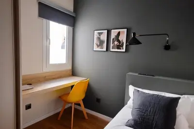 a bedroom with a desk and a bed and a yellow chair at MadreMia - Wow Hub Barcelona in Hospitalet de Llobregat