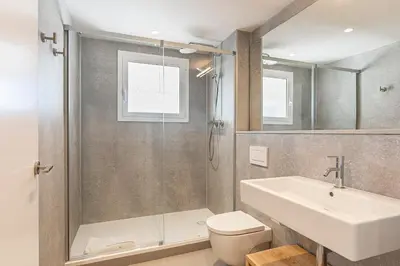 a bathroom with a shower and a toilet and a sink at Penthouse with Terrace near Gran Via and Camp Nou in Barcelona