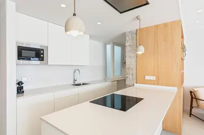 a kitchen with white cabinets and a white counter top at Penthouse with Terrace near Gran Via and Camp Nou in Barcelona
