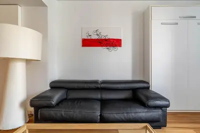 a black leather couch in a living room with a picture at 4101 - AB Passeig de Gràcia Plaça Catalunya I in Barcelona