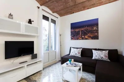 a living room with a black couch and a tv at 2582 - AB Sagrada Familia Marina in Barcelona