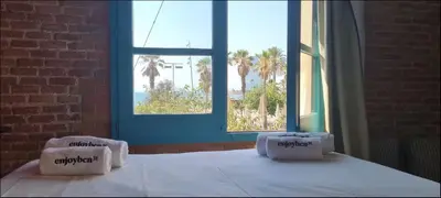 a bed with two pillows in a room with a window at Barceloneta Mar Vela -BM14 in Barcelona