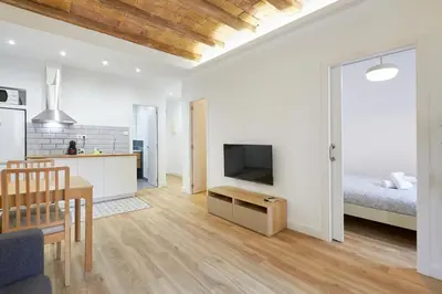 a kitchen and a living room with a bed and a table at Ro Lively and bright apartment next to Blai st in Barcelona