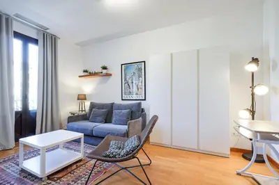 a living room with a blue couch and a table at Gran Via City Center Apartment in Barcelona