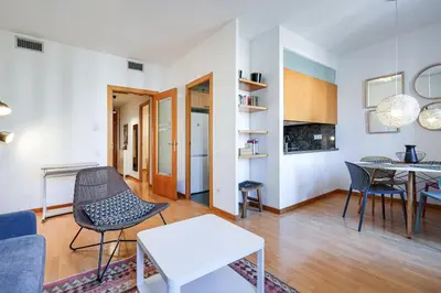 a living room with a table and chairs at Gran Via City Center Apartment in Barcelona