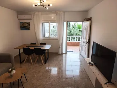 a living room with a dining room table and a television at CasaKech in Vilanova i la Geltrú
