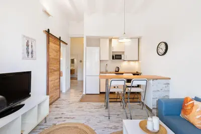 a kitchen and a living room with a table and chairs at Lodging Apartments Pere IV in Barcelona