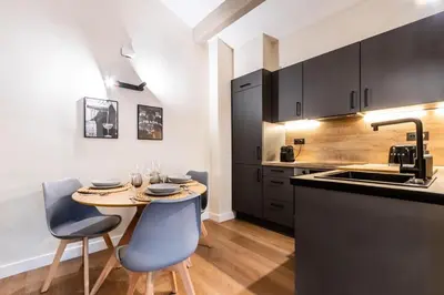 a kitchen with a table and chairs and a sink at Petit Luxe Del Vall in Terrassa
