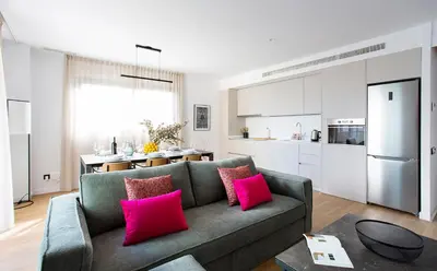 a living room with a gray couch and pink pillows at Durlet Suites by Durlet Apartments in Barcelona