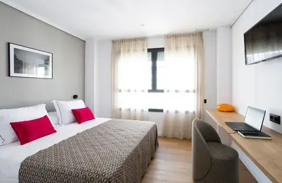 a bedroom with a bed and a desk with a laptop at Durlet Suites by Durlet Apartments in Barcelona