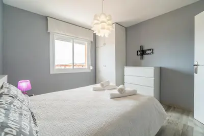 a white bedroom with a large bed and a window at Side Sea Cunit sea views in Cunit