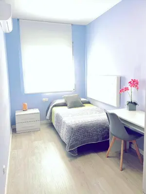 a blue bedroom with a bed and a desk at Precioso apartamento al lado de Barcelona centro in Sant Feliu de Llobregat