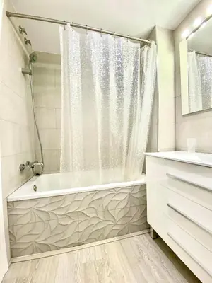 a white bathroom with a tub and a shower at Precioso apartamento al lado de Barcelona centro in Sant Feliu de Llobregat