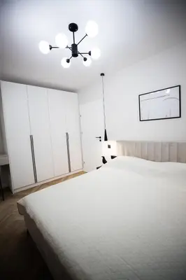 a white bedroom with a large bed and a ceiling at My White Vilanova Home in Vilanova i la Geltrú