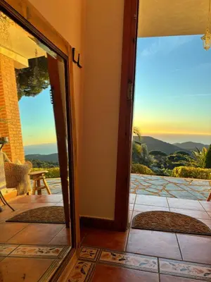 a door leading to a patio with a view of the mountains at Parc du Montnegre avec magnifique vue mer in Tordera