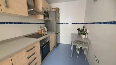 a small kitchen with a table and a refrigerator at Piso in Hospitalet de Llobregat