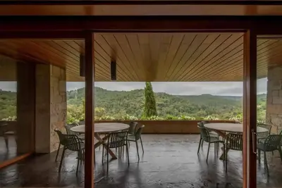 a room with tables and chairs and a large window at Casakubrick mansión in Castelltersol