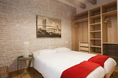 a bedroom with a white bed and a brick wall at Flat with balcony next to the beach, SV in Barcelona