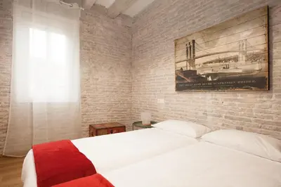 a bedroom with a white bed and a brick wall at Flat with balcony next to the beach, SV in Barcelona