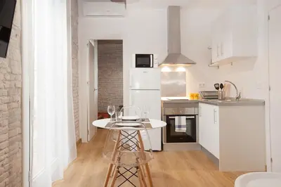 a kitchen with a white table and a white refrigerator at Flat with balcony next to the beach, SV in Barcelona