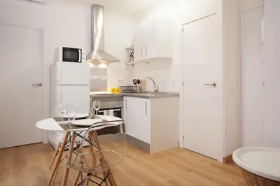 a kitchen with white cabinets and a white refrigerator at Flat with balcony next to the beach, SV in Barcelona