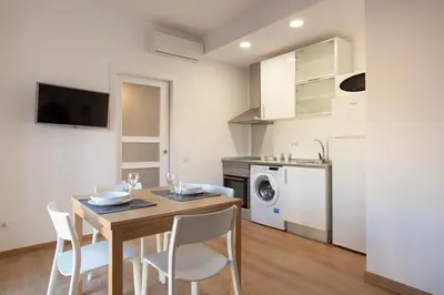 a kitchen and dining room with a table and chairs at Renovated apartment with sea view, VJ in Barcelona