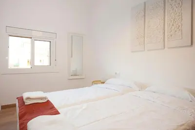 two white beds in a white room with a window at Renovated apartment with sea view, VJ in Barcelona