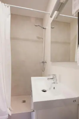 a white bathroom with a sink and a shower at Renovated apartment with sea view, VJ in Barcelona