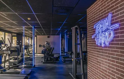 a gym with cardio equipment and a brick wall at BLAU Student Housing - Students Only in Barcelona