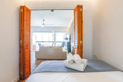 a bedroom with a bed and a mirror with towels at Penelope Apart in Sitges
