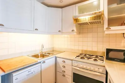a kitchen with white cabinets and a sink and a stove at Penelope Apart in Sitges